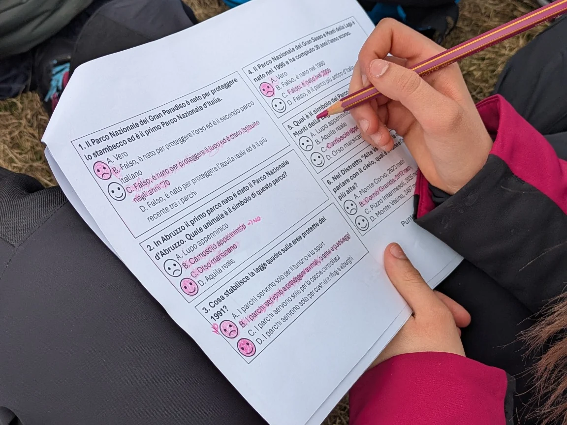 Uno studente compila una scheda didattica sul Parco durante l’attività all’aperto
